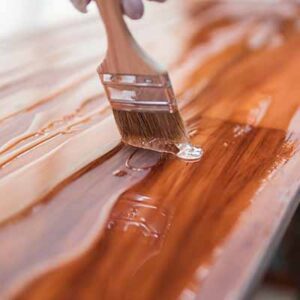 Resin wood coating being applied with brush
